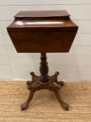 A mahogany work box with three compartments on a turned central column ending in lions paw feet on