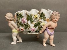 A Sitzendorf porcelain bowl being hold by three cherubs with roses H17cm