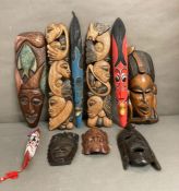 A selection of wall hanging tribal masks and carvings