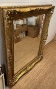 A large wooden gold painted over mantel mirror in the Rococo style 128cm x 159cm