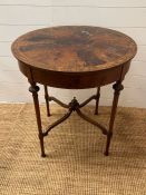 A mahogany occasional table with inlaid top tapering legs jointed by stretchers (H74cm Dia66cm)