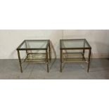 A pair of brass side tables with smoked glass tops