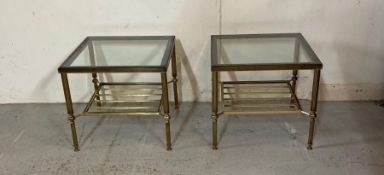 A pair of brass side tables with smoked glass tops