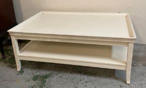 A large white painted coffee table with shelf under
