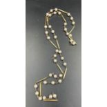 A hallmarked 9ct yellow gold pearl and gold necklace. Made from thirteen solid round wire bars