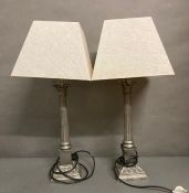 A pair of white metal Corinthian column table lamps