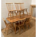 An Ercol Mid Century table and nine chairs (H71cm W150cm D75cm)