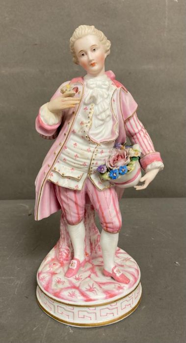 An 19th Century Bisque figure of a gentleman holding a hat with flowers