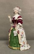 An 19th Century figure of a lady in formal wear with hand raised in the manner of Dresden AF