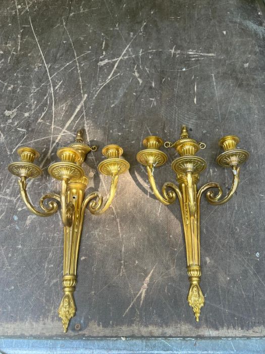 A pair of gilt three arm wall sconces