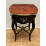 An antique ebonised teapoy with rosewood top and gilt furniture opening to reveal caddy spaces and