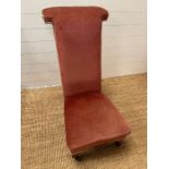 A pink upholstered slipper chair