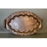 A good Newlyn school hand embossed and planished oval fish dish, with crimped rim, scroll handles,