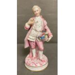 An 19th Century Bisque figure of a gentleman holding a hat with flowers