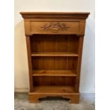 A pine three shelf bookcase with fluted sides and floral detail to top (H115cm W70cm D27cm)