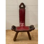 A vintage tripod birthing chair in red leather