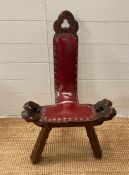 A vintage tripod birthing chair in red leather