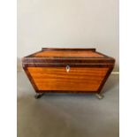 A sarcophagus tea caddy with inlay and brass lion paw feet. Inside has been relined in felt and hand