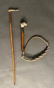 A bone handled hunting whip along with a riding crop.