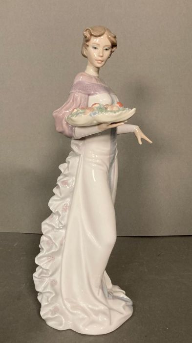 A Lladro lady with a basket of fruit
