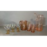 A selection of coloured glass to include champagne coups, cordial jug and glasses