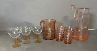 A selection of coloured glass to include champagne coups, cordial jug and glasses