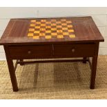 A games table with a checker board top with two drawers to centre and chess pieces in drawer (