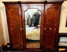 A Victorian walnut veneer triple wardrobe. A breakfront shape top cornice above three doors, two