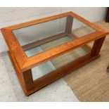 A cherry wood coffee table with glass panel to top and base (H47cm W120cm D80cm)