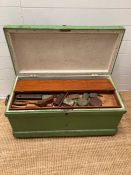 A green painted tool chest containing a selection of vintage tools and planes