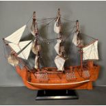 A large wooden scale model of HMS Pinafore on plinth
