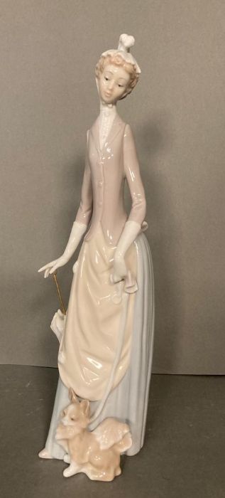 A Lladro lady with umbrella and dog