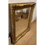 A large wooden gold painted over mantel mirror in the Rococo style 128cm x 159cm