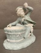 A late Victorian Mintons porcelain figure of a boy with a basket, marked to base