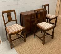 An oak Arts and Crafts style drop leaf dining table and three chairs (H77cm W150cm D90cm)