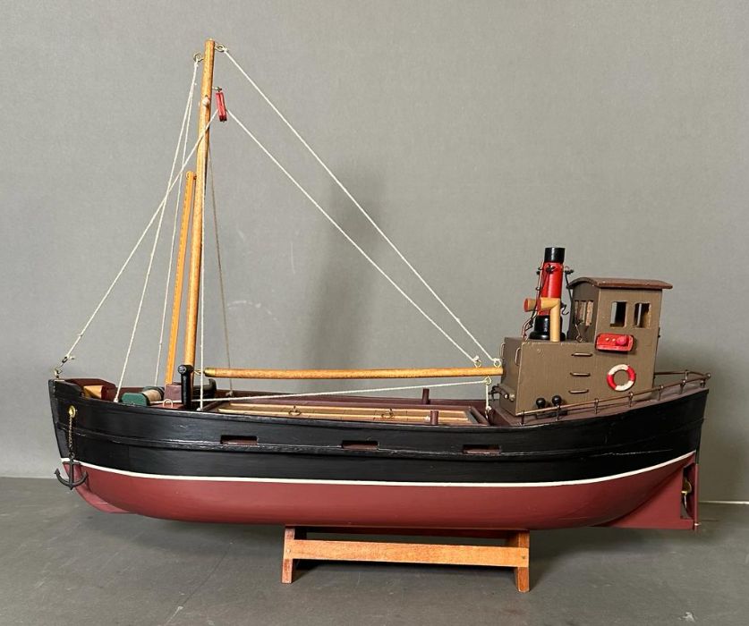 A wooden painted scale model of a Clyde Puffer on stand