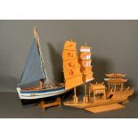 Two wooden scale model boats, a Chinese Junk boat and a small sailing Vessel on stand