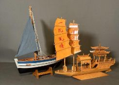 Two wooden scale model boats, a Chinese Junk boat and a small sailing Vessel on stand