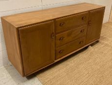 An Ercol three drawer, two cupboard sideboard on castors (H70cm W44cm D156cm)