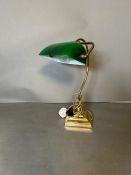 A brass bankers desk lamp with green shade