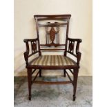 An Edwardian mahogany arm chair wit decorative inlaid splats to back and arms on square tapering