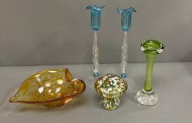 A selection of coloured glass including paper weights vases and candle holders, some signed to base