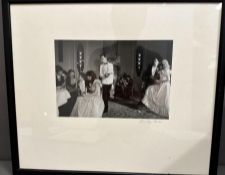 A framed photograph by Dudley Reed of a 1980's dinner party signed