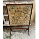 A mahogany framed fire screen on splayed feet with floral tapestry insert