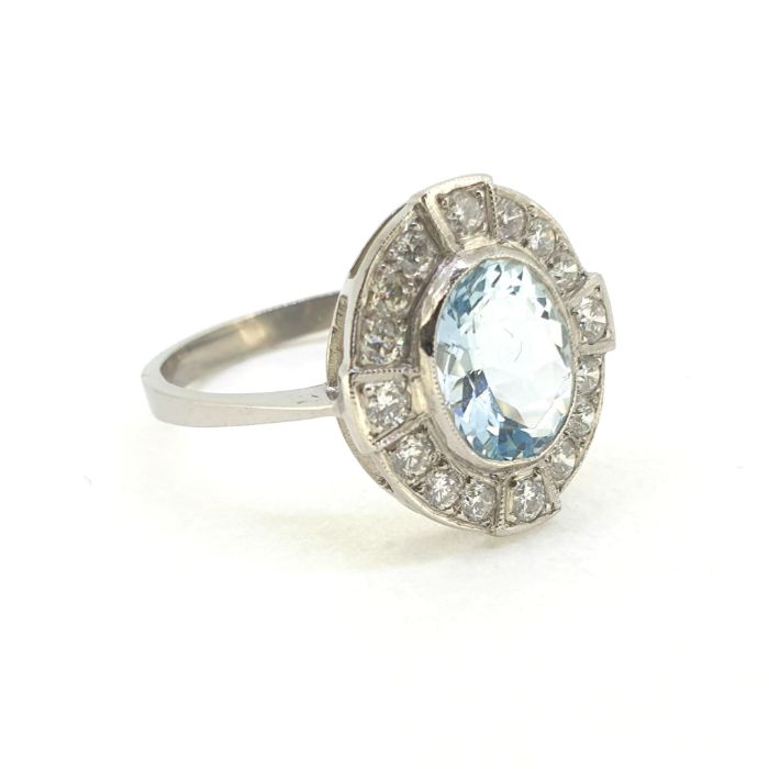 Platinum aqua and diamond cluster ring. The centrally set mixed cut oval aqua is in a rub over