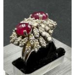A diamond and ruby cluster ring on 18ct, marked 750 white gold with two central stones and