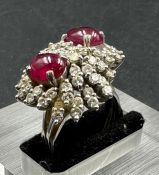 A diamond and ruby cluster ring on 18ct, marked 750 white gold with two central stones and