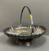 A silver plate scalloped handled tray of muffin dish on a footed base