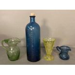 A selection of four vintage coloured glass items, two jugs, a vase and a cobalt blue bottle