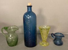 A selection of four vintage coloured glass items, two jugs, a vase and a cobalt blue bottle